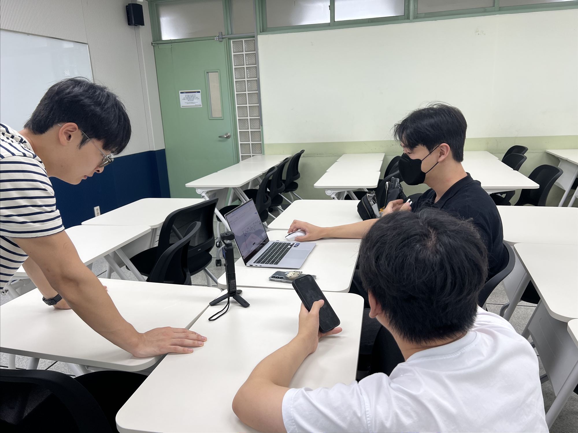 동료가 노트북 화면을 보며 업무를 알려주는 모습